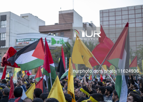 Iranian protesters wave Palestinian flags while taking part in a protest gathering to condemn an Israeli air strike against Hezbollah's head...