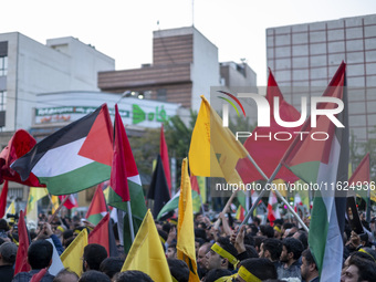 Iranian protesters wave Palestinian flags while taking part in a protest gathering to condemn an Israeli air strike against Hezbollah's head...