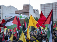 Iranian protesters wave Palestinian flags while taking part in a protest gathering to condemn an Israeli air strike against Hezbollah's head...