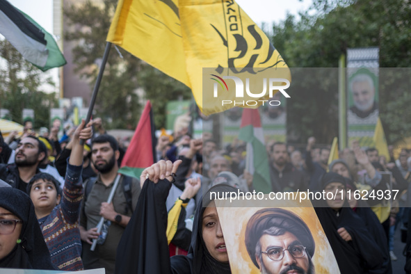 A veiled Iranian protester shouts anti-Israeli and anti-U.S. slogans while carrying a portrait of Lebanon's Hezbollah Secretary General, Has...