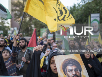 A veiled Iranian protester shouts anti-Israeli and anti-U.S. slogans while carrying a portrait of Lebanon's Hezbollah Secretary General, Has...