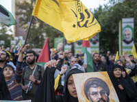 A veiled Iranian protester shouts anti-Israeli and anti-U.S. slogans while carrying a portrait of Lebanon's Hezbollah Secretary General, Has...