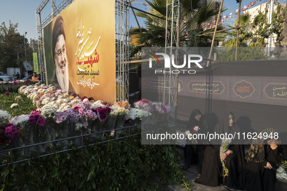 Veiled Iranian protesters sit next to a giant banner depicting a portrait of Lebanon's Hezbollah Secretary General, Hassan Nasrallah, during...