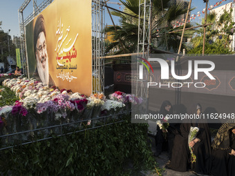 Veiled Iranian protesters sit next to a giant banner depicting a portrait of Lebanon's Hezbollah Secretary General, Hassan Nasrallah, during...