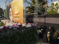 Veiled Iranian protesters sit next to a giant banner depicting a portrait of Lebanon's Hezbollah Secretary General, Hassan Nasrallah, during...