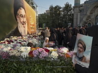 Iranian protesters place flowers under a giant banner featuring a portrait of Lebanon's Hezbollah Secretary General, Hassan Nasrallah, while...