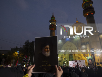 A veiled Iranian protester holds up a portrait of Lebanon's Hezbollah Secretary General, Hassan Nasrallah, while taking part in a protest ga...