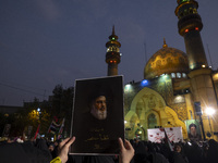 A veiled Iranian protester holds up a portrait of Lebanon's Hezbollah Secretary General, Hassan Nasrallah, while taking part in a protest ga...