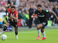 Emerson Palmieri of West Ham chases Brentford's Kevin Schade during the Premier League match between Brentford and West Ham United at the Gt...