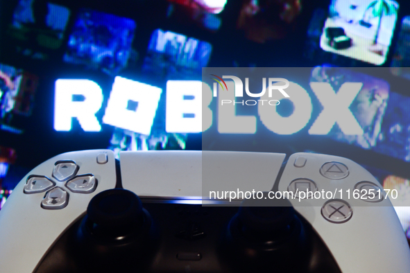 Roblox displayed on a tv screen and  DualSense controller are seen in this illustration photo taken in Krakow, Poland on September 30, 2024....