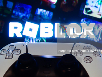 Roblox displayed on a tv screen and  DualSense controller are seen in this illustration photo taken in Krakow, Poland on September 30, 2024....