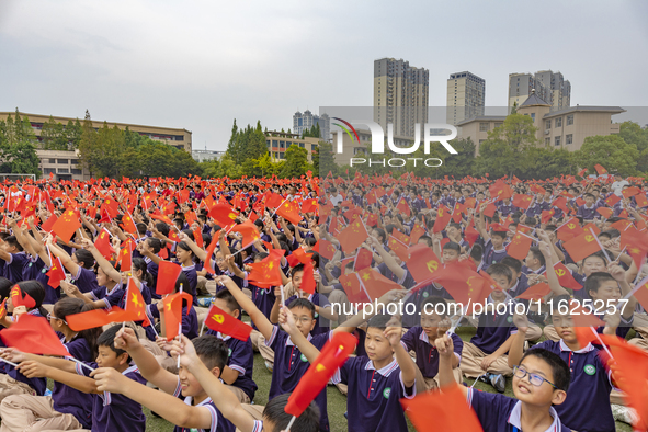 In Suqian, China, on September 30, 2024, 7,000 teachers and students gather at the campus sports field to hold a themed event called ''Repor...