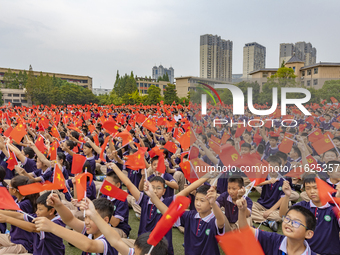 In Suqian, China, on September 30, 2024, 7,000 teachers and students gather at the campus sports field to hold a themed event called ''Repor...