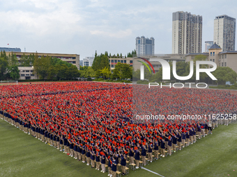 In Suqian, China, on September 30, 2024, 7,000 teachers and students gather at the campus sports field to hold a themed event called ''Repor...