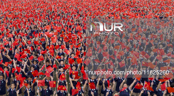 In Suqian, China, on September 30, 2024, 7,000 teachers and students gather at the campus sports field to hold a themed event called ''Repor...