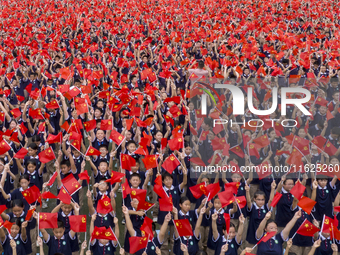 In Suqian, China, on September 30, 2024, 7,000 teachers and students gather at the campus sports field to hold a themed event called ''Repor...