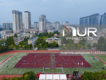 In Suqian, China, on September 30, 2024, 7,000 teachers and students gather at the campus sports field to hold a themed event called ''Repor...