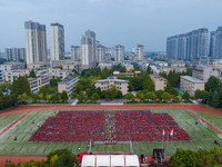 In Suqian, China, on September 30, 2024, 7,000 teachers and students gather at the campus sports field to hold a themed event called ''Repor...