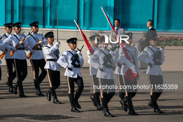 Police officers hold the China National Flag and the HKSAR Flag and march during the flag-raising ceremony in Hong Kong, China, on October 1...