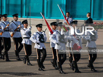 Police officers hold the China National Flag and the HKSAR Flag and march during the flag-raising ceremony in Hong Kong, China, on October 1...