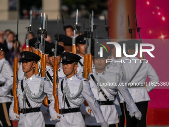 Police hold rifles while marching during the flag-raising ceremony in Hong Kong, China, on October 1, 2024. (