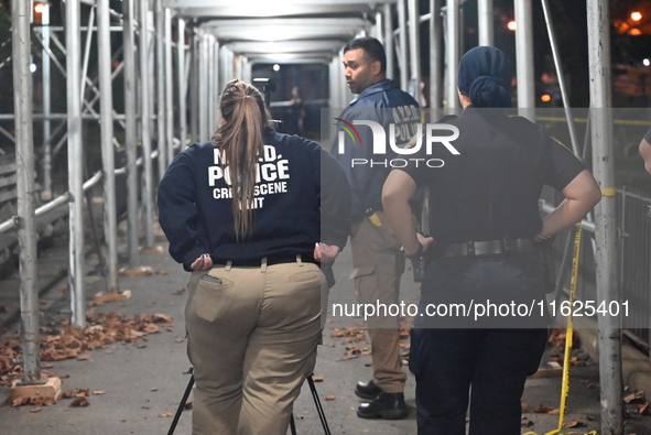 Crime scene investigators mark evidence at the scene where one man is killed and two other men are injured following a shooting in Bedford-S...