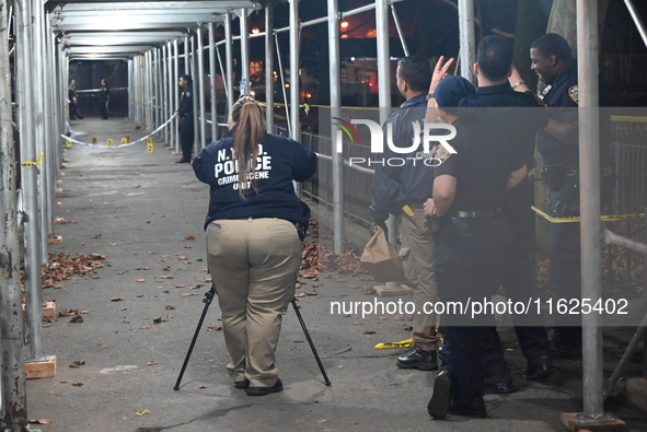 Crime scene investigators mark evidence at the scene where one man is killed and two other men are injured following a shooting in Bedford-S...