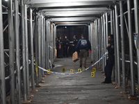 Crime scene investigators mark evidence at the scene where one man is killed and two other men are injured following a shooting in Bedford-S...