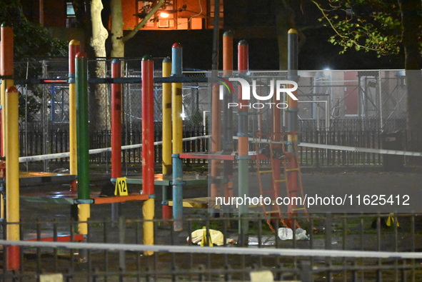 Crime scene investigators mark evidence at the scene where one man is killed and two other men are injured following a shooting in Bedford-S...