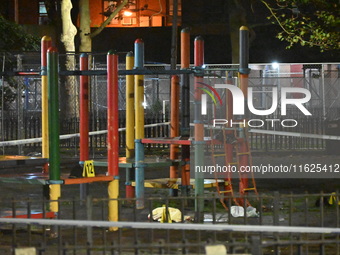 Crime scene investigators mark evidence at the scene where one man is killed and two other men are injured following a shooting in Bedford-S...