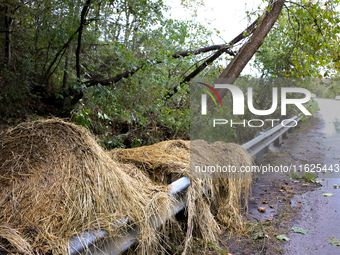 Hay bails lay atop a roadway guardrail in Chilhowie, Virginia on September 30, 2024, after Hurricane Helene caused severe flooding in the re...