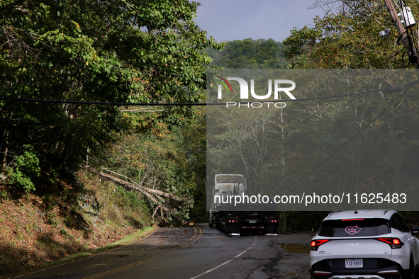 A truck is entangled in wires after passing through a damaged roadway in Whitetop, Virginia on September 30, 2024. 