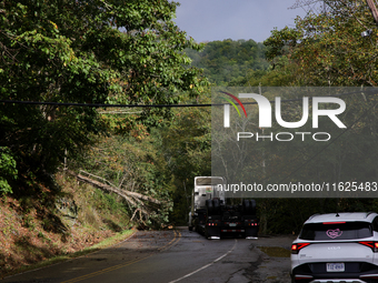 A truck is entangled in wires after passing through a damaged roadway in Whitetop, Virginia on September 30, 2024. (