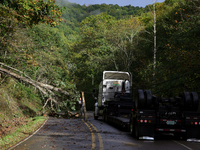 A truck driver works to remove entangled wires after passing through a damaged roadway in Whitetop, Virginia on September 30, 2024 after Hur...