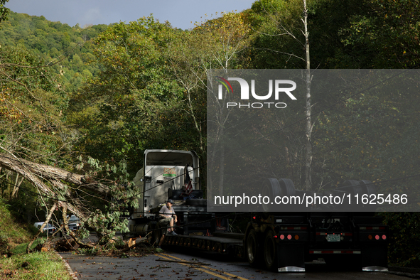 A truck driver works to remove entangled wires after passing through a damaged roadway in Whitetop, Virginia on September 30, 2024 after Hur...