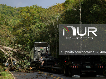 A truck driver works to remove entangled wires after passing through a damaged roadway in Whitetop, Virginia on September 30, 2024 after Hur...