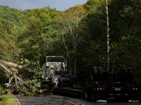 A truck driver works to remove entangled wires after passing through a damaged roadway in Whitetop, Virginia on September 30, 2024 after Hur...