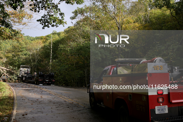 A truck is entangled in wires after passing through a damaged roadway in Whitetop, Virginia on September 30, 2024. 