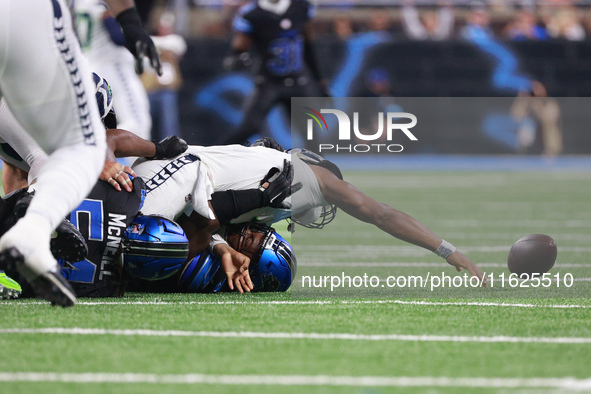 DETROIT,MICHIGAN-September 30: Seattle Seahawks quarterback Geno Smith (7) gets sucked by Detroit Lions defensive end Levi Onwuzurike (91) d...