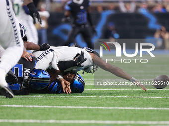 DETROIT,MICHIGAN-September 30: Seattle Seahawks quarterback Geno Smith (7) gets sucked by Detroit Lions defensive end Levi Onwuzurike (91) d...