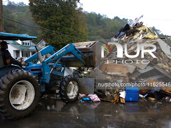 A bulldozer piles collected debris in Lansing, North Carolina on September 30, 2024 after Hurricane Helene caused widespread damage to the r...