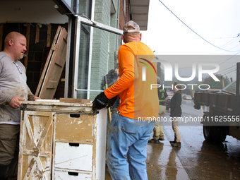 People remove furniture from a business in Lansing, North Carolina on September 30, 2024 after Hurricane Helene caused widespread damage in...