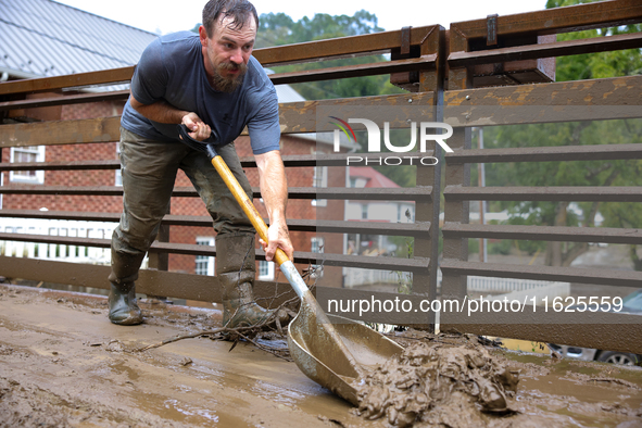 Austin, a resident of Lansing, North Carolina, clears debris from a bridge on September 30, 2024 after Hurricane Helene caused widespread fl...