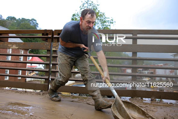 Austin, a resident of Lansing, North Carolina, clears debris from a bridge on September 30, 2024 after Hurricane Helene caused widespread fl...