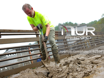 Mike, a resident of Lansing, North Carolina, clears debris from a bridge on September 30, 2024 after Hurricane Helene caused widespread floo...