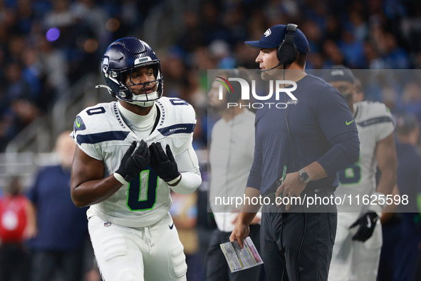 DETROIT,MICHIGAN-September 30:Seattle Seahawks head coach Mike Macdonald talks to linebacker Tyrel Dodson (0) during the first half of an NF...