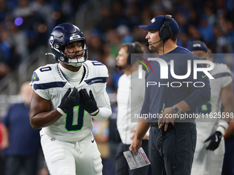 DETROIT,MICHIGAN-September 30:Seattle Seahawks head coach Mike Macdonald talks to linebacker Tyrel Dodson (0) during the first half of an NF...