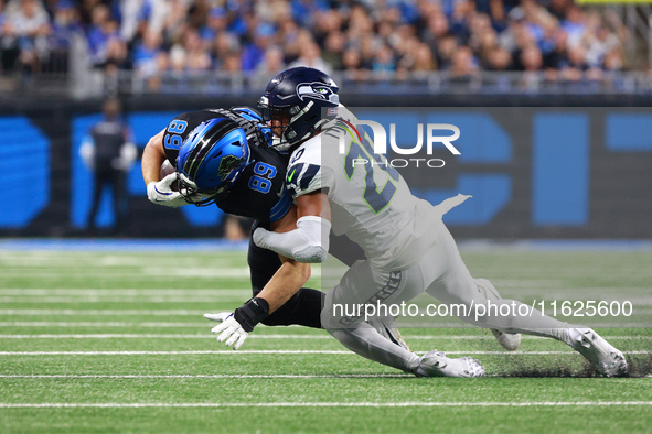 DETROIT,MICHIGAN-September 30: Detroit Lions offensive tackle Taylor Decker (68) is tackled by Seattle Seahawks safety Julian Love (20) duri...