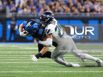 DETROIT,MICHIGAN-September 30: Detroit Lions offensive tackle Taylor Decker (68) is tackled by Seattle Seahawks safety Julian Love (20) duri...