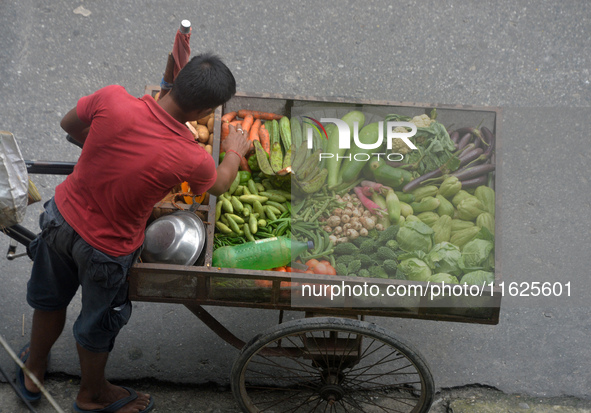 A vegetable seller arranges his van loaded with vegetables as he ferries it for sale to houses in Siliguri, India, on October 1, 2024. 